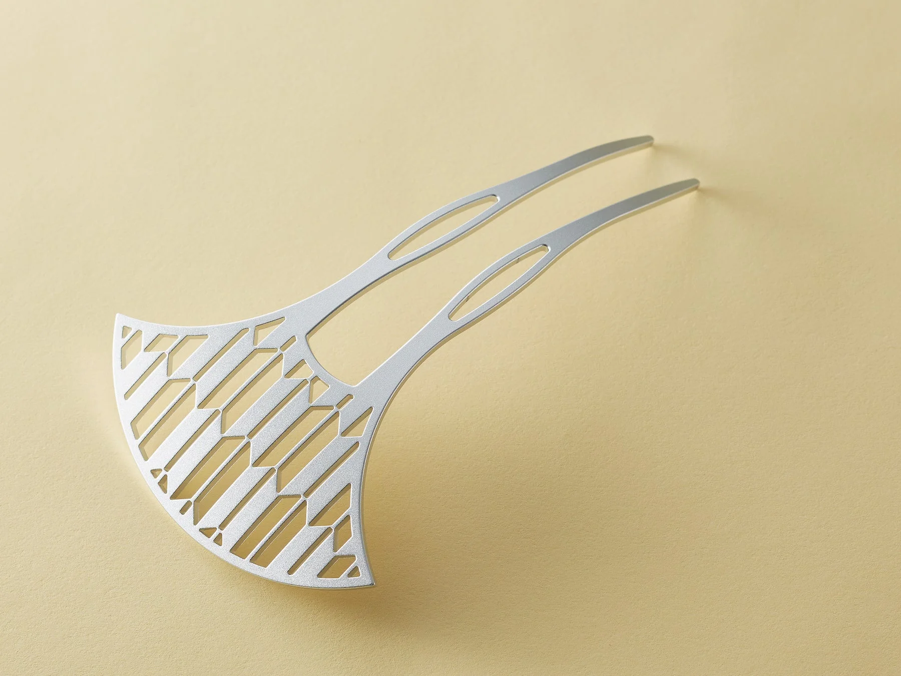 幾何学的な透かし彫りが施された銀色の髪飾り