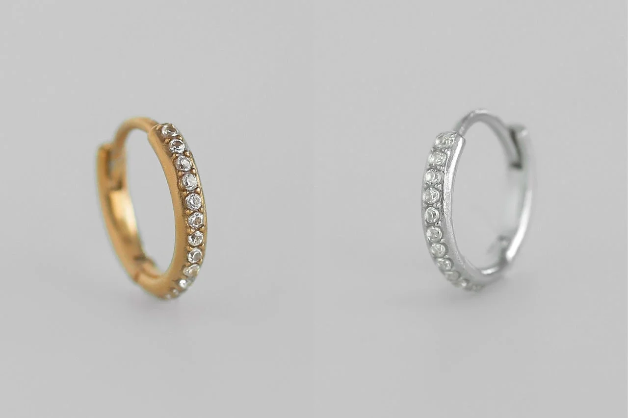 ゴールドとシルバーの輝く石が並んだフープピアス