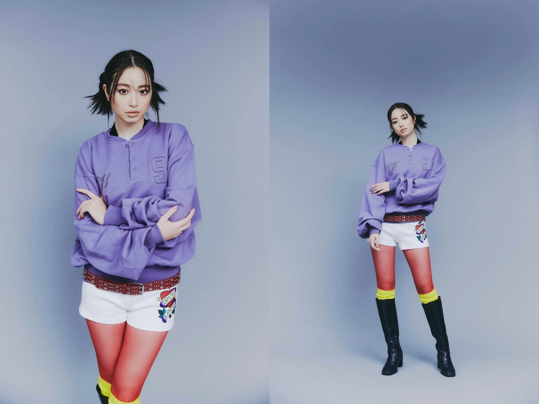 リップピアスと特徴的なツインテールの女性がスタジオでポーズをとっています。パープルのトップス、ハート柄のショートパンツ、赤いタイツと黒いブーツを着用し、個性的でエッジの効いたファッションスタイルを披露しています。