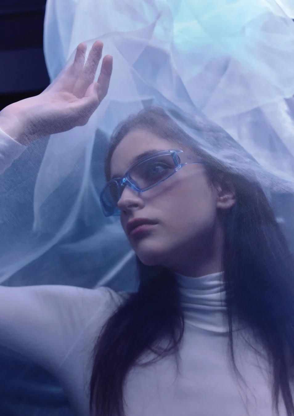 青い未来的なサングラスをかけた女性が、白いベールを頭上に持ち上げているポートレート。クールでミステリアスな雰囲気を醸し出しています。