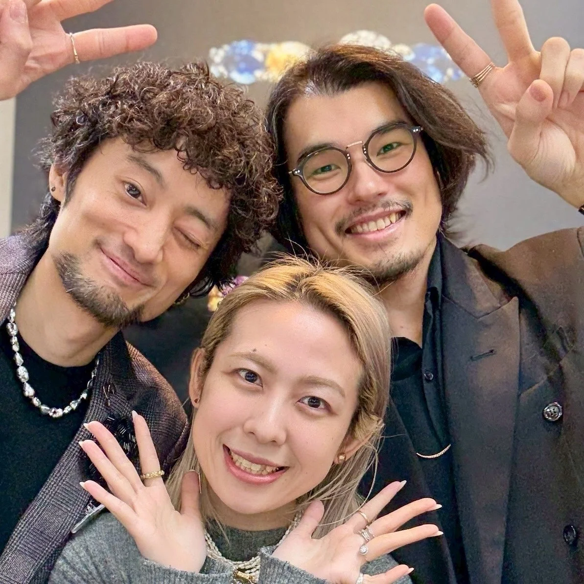 笑顔でポーズをとる3人の男女の集合写真